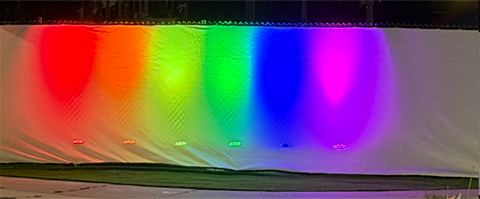 Row of rainbow colored lights on a white background.